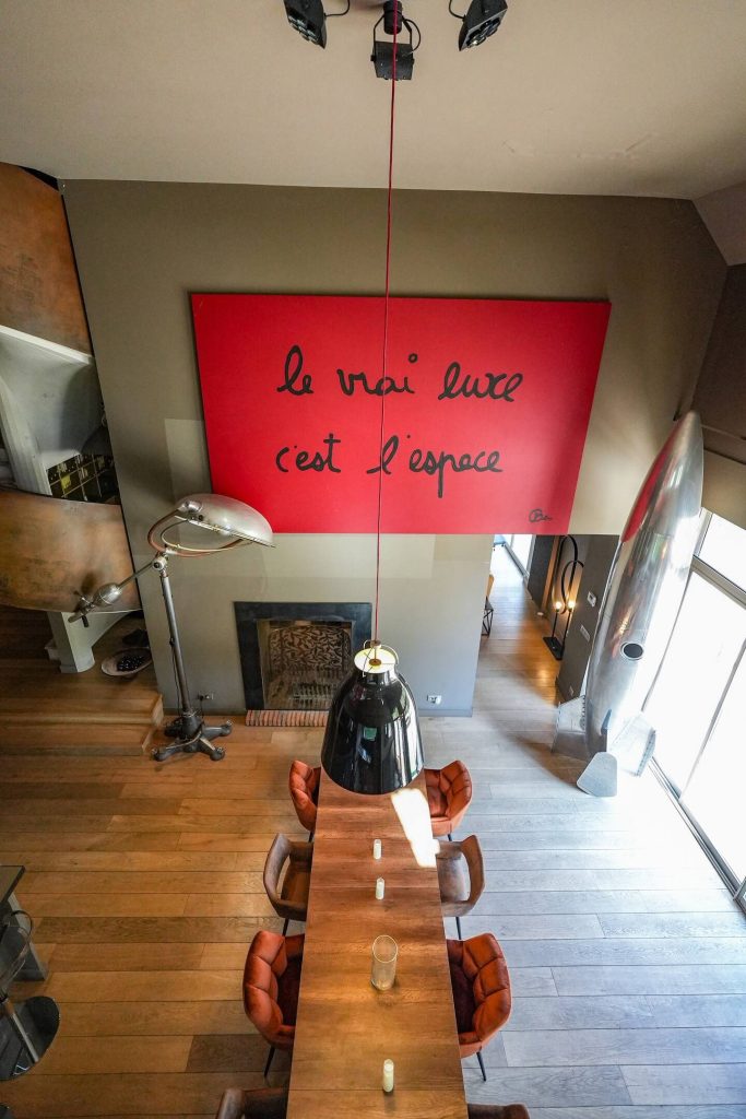 Le salon au mur rouge et sa cheminée
